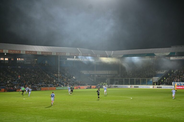 Football match under stadium lights, capturing the dynamic atmosphere and player action.